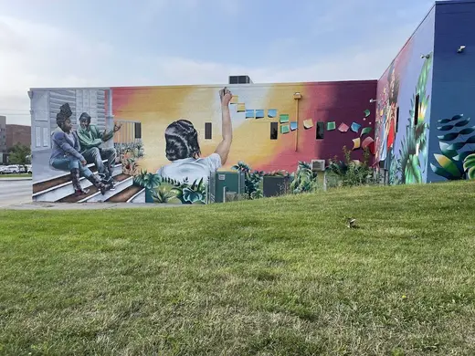 Vibrant mural depicting community support at Evelyn K. Davis Center For Working Families, a detox center in Iowa.